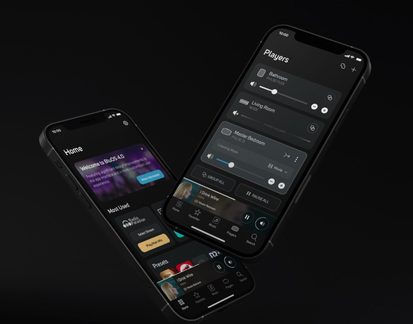 Два чорні смартфони з алюмінію та скла з увімкненими екранами на аудіоінтерфейсі, зображені в діагональній перспективі на чорному тлі