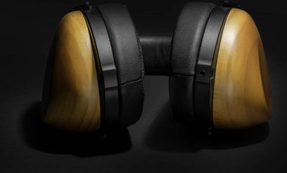 Hifiman HE-R10D åbne hi-fi-hovedtelefoner i sort læder og lyst træ, close-up forfra på ørekopperne og hovedbøjlen