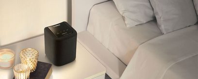 Trådløs, tilsluttet Yamaha WX-010 sort højttaler placeret på en hvid sofa, set forfra i let nedadgående vinkel