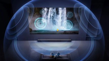 Velkoformátový nástěnný televizor se soundbarem, modrý surround efekt v obývacím pokoji domácího kina