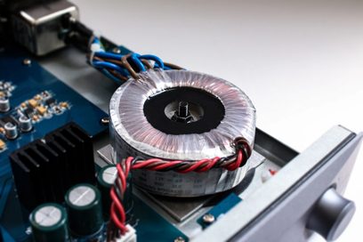 Nuprime Alita Sølv audio DAC-konverter, tæt ovenfra-billede af toroidaltransformer, blå printplader og røde kabler