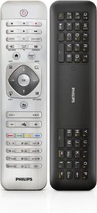 To Philips fjernbetjeninger, en grå med knapper og drejeknap, den anden sort med numerisk tastatur og funktionstaster