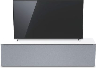 Šedý televizní nábytek v tmavých a světlých odstínech s černou plochou TV, pohled zepředu z mírného nadhledu na bílém pozadí