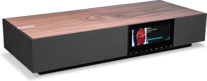 Бездротова підключена колонка Cambridge Audio EVO ONE, вид з трьох чвертей, верхня частина з дерева, чорна передня панель, центральний кольоровий екран