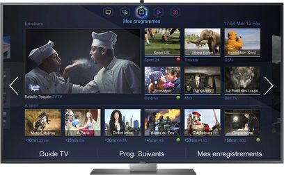 Samsung UE65F9000-fladskærm, der viser en brugergrænseflade med miniaturebilleder af tv-programmer, set forfra