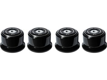 Quattro supporti antivibranti in ceramica nera e metallo argentato di forma cilindrica, visti dall'alto, allineati