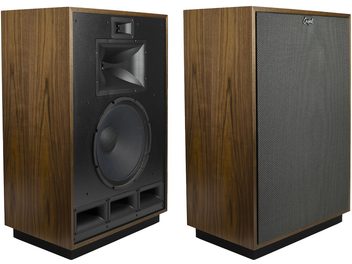 Colunas Klipsch Cornwall IV acabamento nogueira, caixa de madeira marrom com veios e base preta, vista em três quartos mostrando em uma delas o difusor preto, grande woofer e três dutos retangulares, enquanto a outra possui uma grade de tecido cinza antracite.
