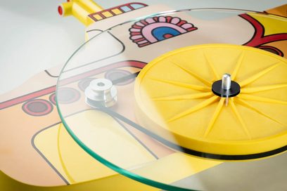 Pro-Ject Yellow Submarine hi-fi turntable with a transparent glass platter, yellow sub-platter, and metal central spindle