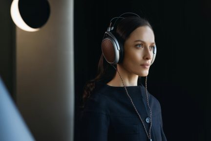 Circumauralt headset med kobberfarvet cirkulært metalgitter, snoet kabel, båret af en person med langt hår