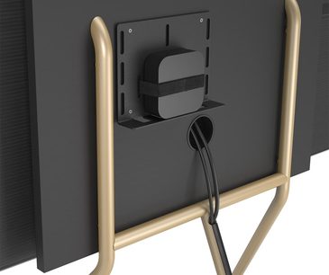 Sort TV-møbel med integreret TV-stander, hylde, kabelbakke og forgyldte ben, set bagfra i perspektiv