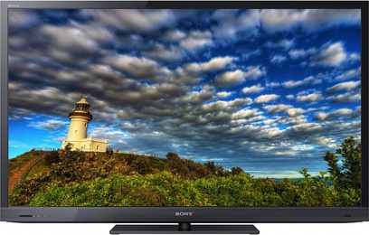 Sony KDL-32EX720 TV-skærm, der viser et fyrtårn på en grøn bakke under en blå og hvid skyet himmel
