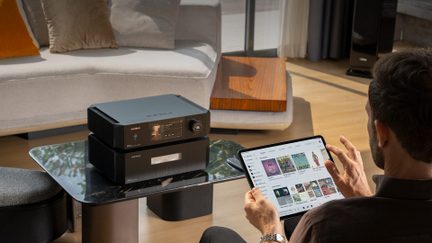 Amplificatore di rete hi-fi nero Eversolo su tavolino basso con controllo della musica su tablet in un salotto
