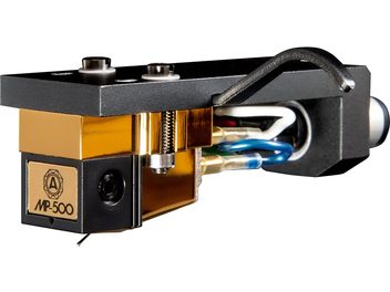Nagaoka MP-500H cartridge in gold and black metal, close-up from the front left three-quarter view, mounted on a black headshell with two screws, featuring a logoed front plate and multicolored wiring visible at the rear