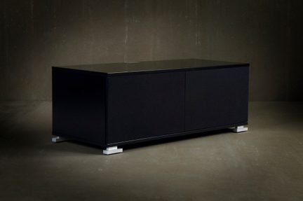 Mobile basso rettangolare nero, due ante lisce senza maniglie, piano lucido, vista a tre quarti, piedini metallici