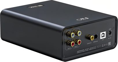 Передпідсилювач для навушників FiiO K7 у чорному матовому алюмінії, вид ззаду під кутом, що демонструє кольорові роз'єми RCA, коаксіальний, оптичний, USB-B порти та роз'єм живлення