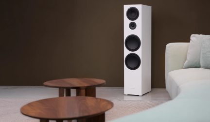 Diffusore da pavimento hi-fi bianco con tre woofer e tweeter, collocato in un salotto moderno
