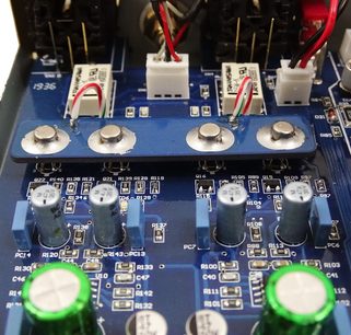 Modrý tištěný spoj s elektronickými součástkami, 4 stříbrnými tlačítky, 2 zelenými rozsvícenými LED diodami a připojenými červenými kabely