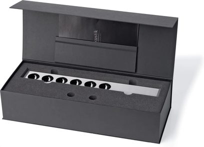 Multiprise Inakustik AC-3200 Filter Digital SCHUKO i børstet sølvaluminium med række af runde sorte stikkontakter, set fra trekvart ovenfra i en sort æske med beskyttelsesskum