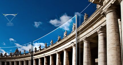 Columnata de estilo clásico con estatuas en la parte superior, bajo un cielo azul con algunas nubes blancas
