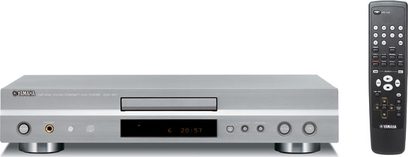 Yamaha CDX-497 CD-afspiller set forfra, sølvfarvet front med digitalt display, knapper og CD-bakke, sort fjernbetjening ved siden af
