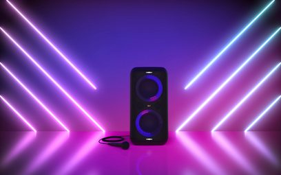 Klipsch GIG XXL sort trådløs Bluetooth-højttaler, set forfra, med lilla LED-lys, på lilla baggrund med lysende stråler