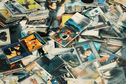 Scattered clear plastic CD cases, multicolored covers, top view