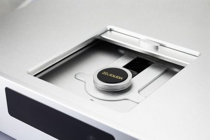 Topvinkel billede af den sølvfarvede Jolida JD100 MKII CD-afspiller med åbent låg, der viser CD-skuffen og logoet