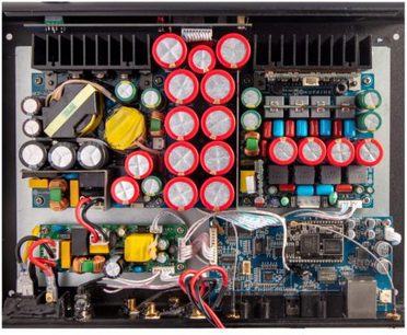 Interno di un amplificatore hi-fi con circuiti stampati, componenti elettronici colorati e dissipatori di calore in alluminio