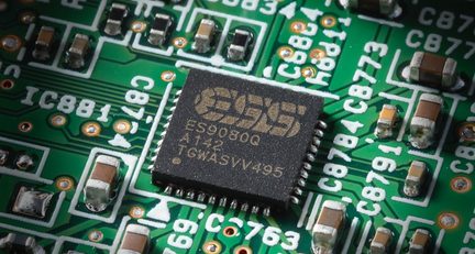 Circuit integrat ESS ES9080Q negru montat pe placă electronică verde, vedere macro a pistelor și componentelor SMD