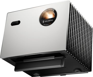 Valerion StreamMaster Plus 2 silver-gray metal projector, smooth front panel with branded circular window and black sensor on the left, large black mesh side grille, three-quarter front low-angle view