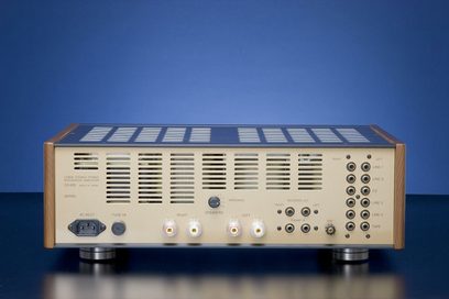Leben CS600 Röhren-HiFi-Verstärker aus hellem Holz, goldene Frontplatte mit Knöpfen und Anschlüssen, Frontansicht auf einfarbigem blauem Hintergrund