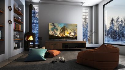 Moderne stue med brun sofa, farverige puder, træhylder, pejs og stort fladskærms-TV, der viser en fantastisk scene