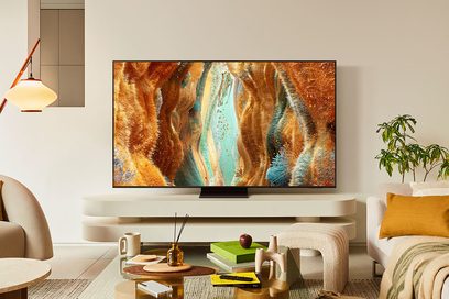 Televizor s plochou obrazovkou v černé barvě, s ultra tenkým kovovým rámem a skleněným panelem, pohled zepředu, umístěný na černém lesklém centrálním obdélníkovém stojanu, zobrazující abstraktní obraz v oranžových a tyrkysových tónech