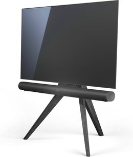Sortlakeret, matblankt TV-møbel i mørkt træ på V-formede ben, med stort, rektangulært fladskærms-TV stående ovenpå, set fra 3/4 vinkel