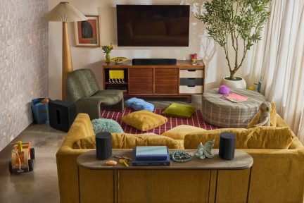 Sort trådløst hjemmebiografsystem med soundbar, subwoofer og to højttalere i en stue