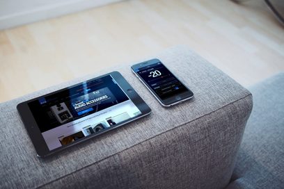 SVS SB-1000 PRO subwoofer i piano gloss black, lakeret sort, og smartphone der viser kontrolappen, set ovenfra