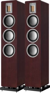 Dva sloupové reproduktory AudioVector QR5 v ořechovém provedení, pohled zepředu, tmavé dřevěné provedení, každý sloup se třemi kulatými černými reproduktory