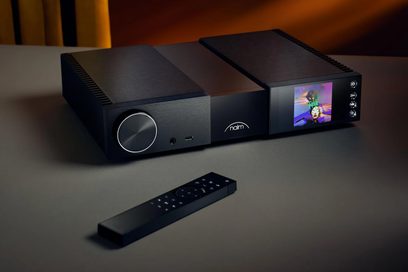 Naim Audio NSC 222 sort forstærker, set forfra med fjernbetjening, skærm der viser et farveillustration