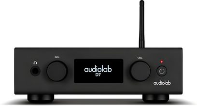 Skats no priekšpuses uz melnu metāla Audiolab D7 DAC, taisnstūrveida korpuss uz kājiņām ar centrālo apgaismoto ekrānu, diviem apaļiem grozāmiem regulatoriem, austiņu ligzdu, LED barošanas pogu un vertikālu antenu.