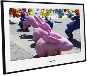 Sony KDL-26E4000 fladskærms-TV, der viser farverige keramiske kaniner på et gråt, heksagonalt flisegulv