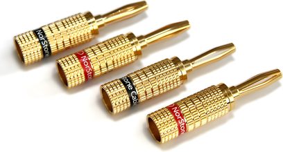 Vier goldene Bananenstecker von Norstone Cable mit roten und schwarzen Kappen, auf weißem Hintergrund ausgerichtet