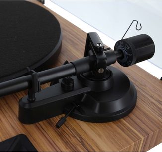 Černý vinylový gramofon s raménkem na dřevěné základně, detailní pohled shora