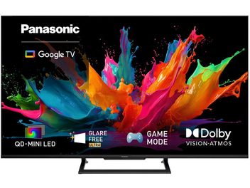 Μαύρη τηλεόραση Panasonic TN-65W90C σε πόδια στήριξης, με πολύχρωμες πιτσιλιές χρώματος στην οθόνη και λογότυπο Google TV