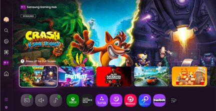 Schermo piatto nero lucido in vetro, cornice sottile nera, vista frontale, visualizzazione di un’interfaccia Samsung Gaming Hub multicolore con una grande miniatura di “Crash Bandicoot”, fila inferiore di icone circolari dei servizi di gioco