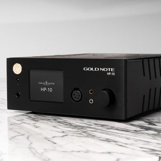 Amplificador negro rectangular con panel frontal que incluye pantalla, botón giratorio, conectores de audio y logotipo dorado en relieve