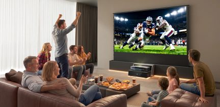 Προβολέας home cinema υπερβραχείας εστίασης σε σαλόνι, οικογένεια μπροστά σε έναν αγώνα αμερικανικού ποδοσφαίρου σε μεγάλη οθόνη