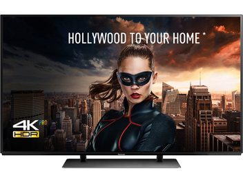Panasonic TX-55EZ950E 4K HDR-fladskærm viser en maskeret brunhåret kvinde i en by med skyskrabere