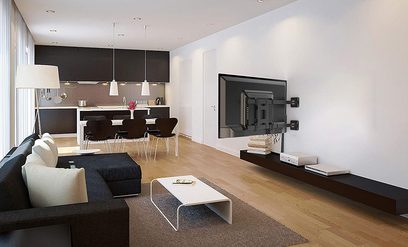 Moderne stue med mørk grå hjørnesofa, hvidt sofabord, åbent sort og hvidt køkken, vægmonteret fladskærm