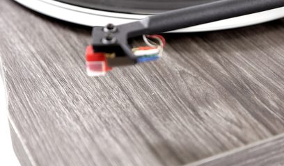 New Horizon 129 mørkebrun pladespiller med valnøddefinish, nærbillede af pickuppen og tonearmen på en plade
