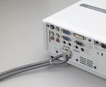 Videoprojektor Mitsubishi WL2650U v bílé barvě, detailní zadní pohled zobrazující audio/video konektory a připojený šedý napájecí kabel